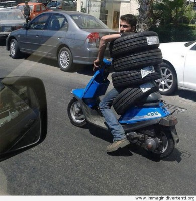divertente-uomo-che-trasporta-i-pneumatici-con-la-moto.jpg